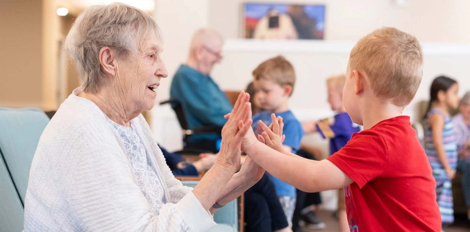older woman high fiving a young boy