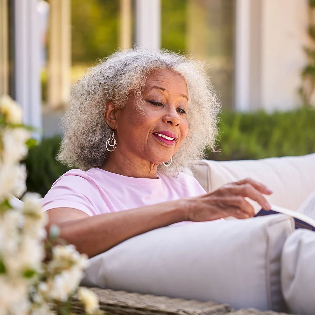 a woman sitting on a couch reading a book
