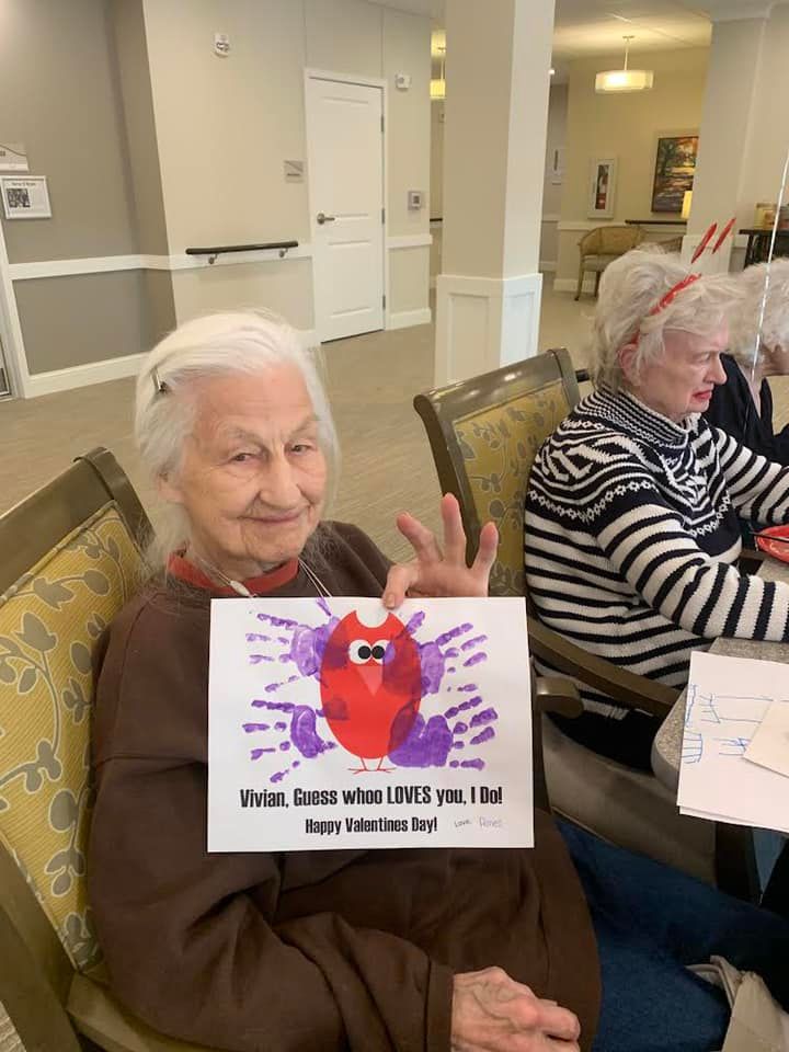 Resident at Riley Crossing Senior Living with her card from the child care kids