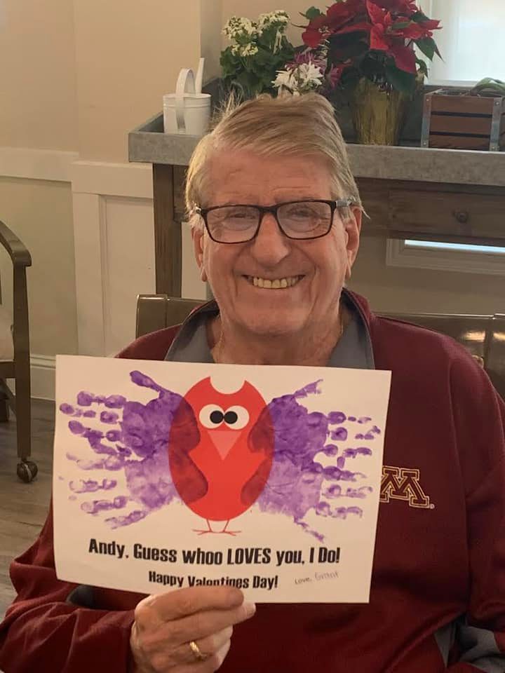 Senior living resident proudly displaying his Valentine’s Day card from Riley Crossing Child Care